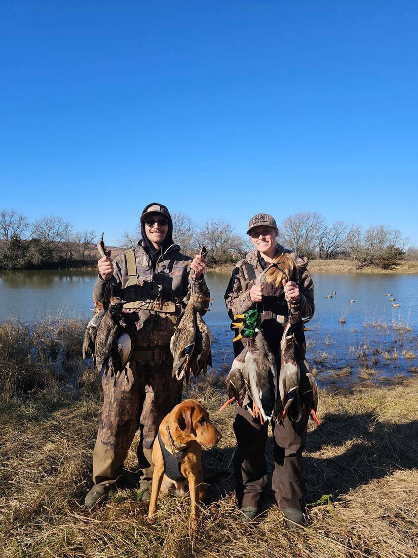 Two hunters and a retriever at the water's edge after the morning hunt